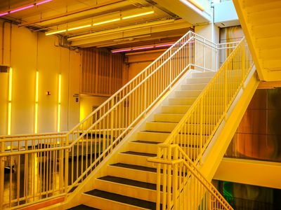 Geometric violet shapes balancing in a neon light environment